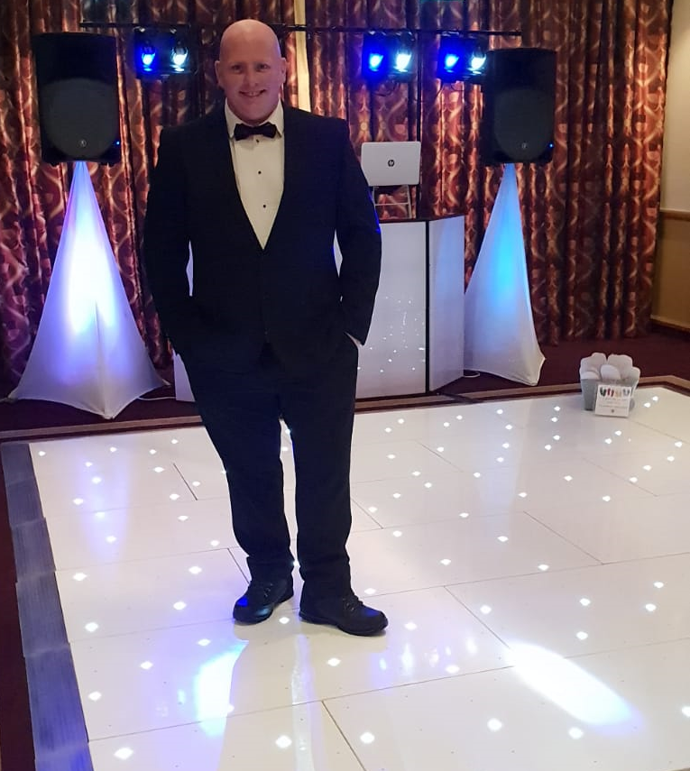 DJ in tux standing on LED disco dance floor for hire